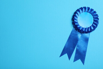 Wall Mural - blue award ribbon on turquoise background, top view. space for text