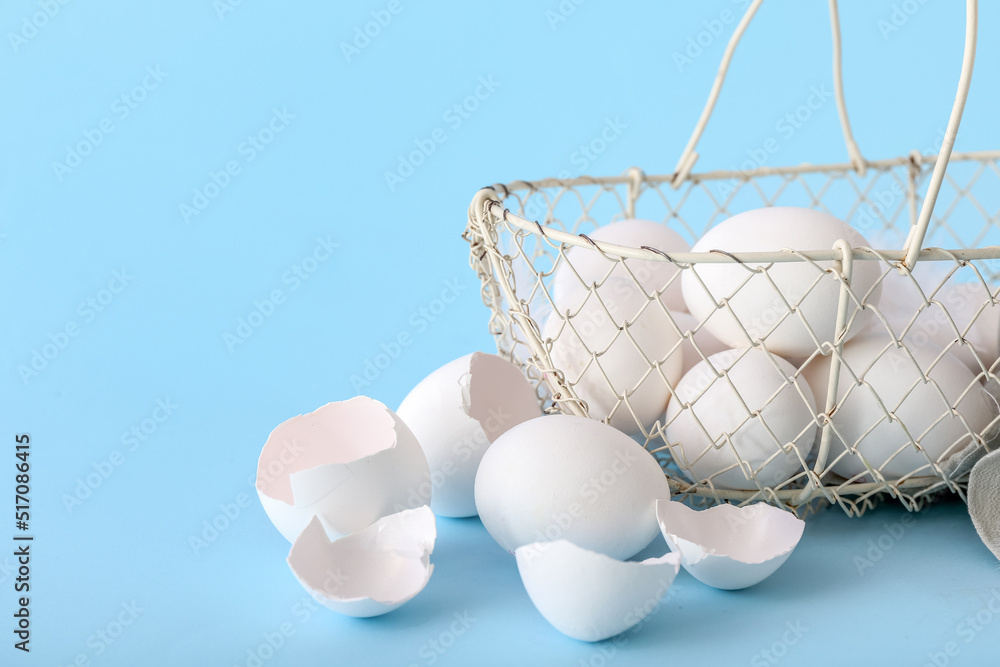 Basket with white chicken eggs on color background
