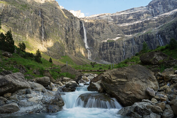 Cirque de Gavarnie beautiful waterfall with river underneath high cliffs, Pyrenees Mountains, France