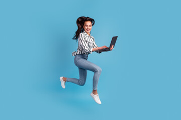 Photo of pretty charming woman dressed shirt holding using device jumping running isolated blue color background