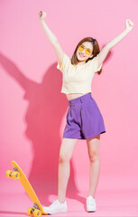 Wall Mural - Photo of Asian teenager girl with skateboard on pink background