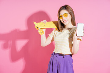 Wall Mural - Photo of Asian teenager girl with skateboard on pink background