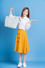 Wall Mural - Full length photo of young Asian woman on blue background