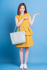 Wall Mural - Full length photo of young Asian businesswoman on blue background