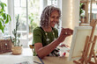 © Caia Image - Happy senior woman painting at easel