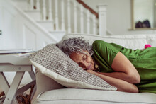Serene Senior Woman Napping On Living Room Sofa