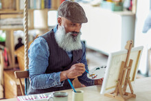 Mature Man With Beard Painting At Easel
