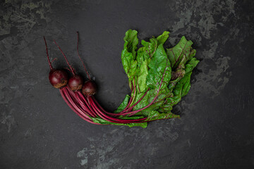 Wall Mural - Raw beetroot with herbage leaves on a dark background. banner, menu, recipe place for text, top view