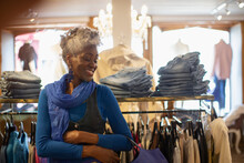 Happy Senior Woman Shopping In Clothing Boutique