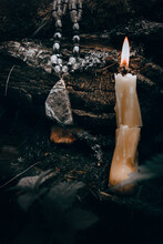 Burning Candle, A Symbol Of The Moon, An Amulet Lying On The Moss On A Dark Natural Background. Pagan Wiccan, Slavic Traditions. Witchcraft, Esoteric Spiritual Ritual . Autumn Equinox Festival