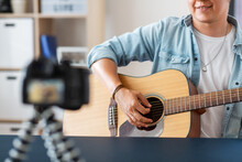 Music, Blogging And People Concept - Close Up Of Male Guitarist Or Musician With Camera Playing Acoustic Guitar And Recording Video Or Live Streaming At Home
