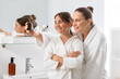 © Syda Productions - beauty, hygiene, morning and people concept - happy smiling mother and daughter taking selfie with smartphone at bathroom