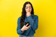 © luismolinero - Young caucasian woman isolated on yellow background thinking and sending a message