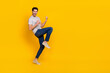 Full size photo of cool brunet young guy yell wear t-shirt jeans footwear isolated on yellow background