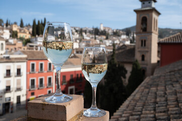 Two glasses of Spanish dry rueda white wine served on roof terrace with view on old part of Andalusian town Granada, Spain