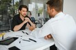 © Serhii - two people sit in front of construction plan and talk about the architecture