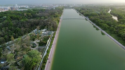 Canvas Print - Beautiful view of a river surrounded by a park in a city