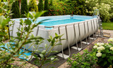 Fototapeta  - Above ground, rack swimming pool in the garden. Summer holiday recreation.