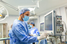 Medical Ventilator Being Monitored By Anaesthetist. Surgeon Using Monitor In Operating Room.