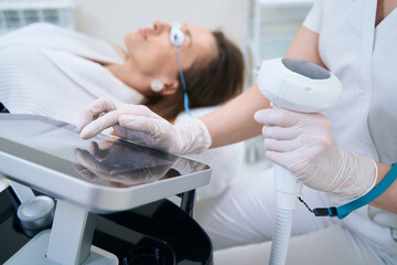 Canvas Print - Doctor adjusts the apparatus for photorejuvenation of the skin