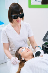 Canvas Print - Female patient in cosmetology center undergoes neck skin rejuvenation procedure