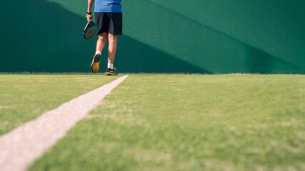 Wall Mural - Monitor practicing paddle sport on the outdoor court. Man teaching padel class