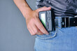 Hand holds pager weighing on belt jeans.