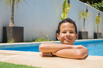 Poster - Happy young boy relaxing on the side of a swimming pool. Summer holidays concept.