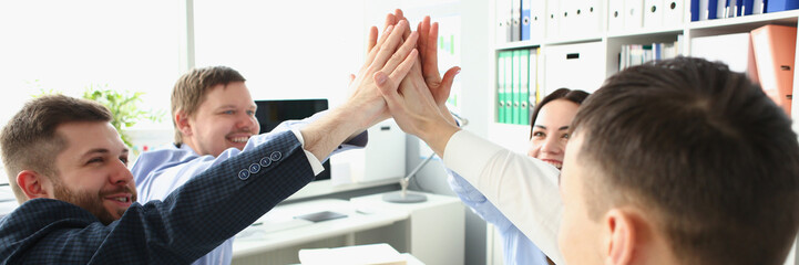 Wall Mural - Witty colleagues performing high five gesture in order to celebrate important profitable project