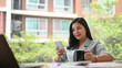 © Prathankarnpap - Pretty asian employee using mobile phone during taking coffee break at modern office
