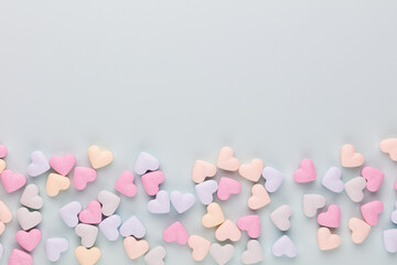 Poster - Composition with candy hearts on pastel blue background.