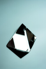 Wall Mural - Shiny glass pyramid on a mirrored surface. Geomtric minimalist object.