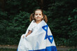 Little girl with the flag of Israel on nature background