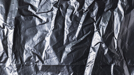 Wall Mural - The background image of black plastic trash bags has creases creating a rough texture with light and shadow.