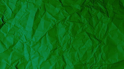 Wall Mural - The green paper background is wrinkled, creating a rough texture with light and shadow.