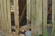 © butus - part of an old wooden fence wall made of broken gray green planks on a rural street