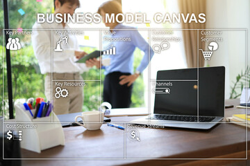 Wall Mural - Business model canvas on the blurring work desktop background and two-person discussion beside the office window.