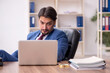© Elnur - Young male employee sitting at workplace