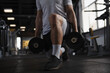 Cropped shot of a sportsman doing weighted lunges at gym