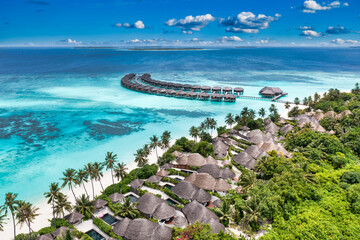 Wall Mural - Aerial view of Maldives island, luxury travel water villas resort and wooden pier. Beautiful sky and ocean lagoon beach background. Summer vacation holiday. Paradise aerial landscape panorama