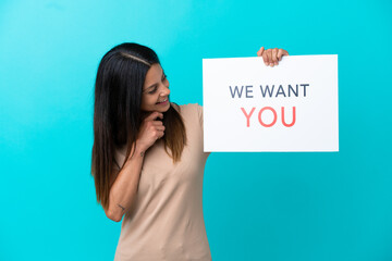 Wall Mural - Young woman over isolated background holding We Want You board with happy expression