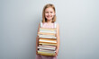 © Ievgen Skrypko - Little girl with backpack and textbooks stack on gray background