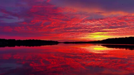 Wall Mural - Amazing red sky mirrored in still waters at dawn, dynamic moving perspective.
