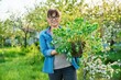 © Valerii Honcharuk - Beautiful middle aged woman with rooted sedum plant looking at camera