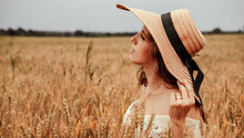 Woman Wheat Field Nature. Happy Young Woman In Sun Hat In Summer Wheat Field At Sunset. Copy Space, Sunset, Flare Light, Summer Season. Boho Chic Style.