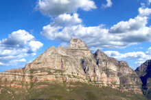 Landscape Of Mountains On A Blue Cloudy Sky. Beautiful View Of Mountain Outcrops With Hill Covered In Green Grass, Shrubs And Bushes On Popular Landmark Or Hiking Location In Cape Town, South Africa
