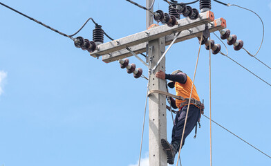 Electrician lineman repairman worker at climbing work on electric post power pole