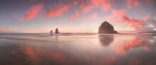 The Sunset At Cannon Beach With Dramatic Clouds In The Background And A Nice Reflection In Water. 
Dramatic Coastal Seascape Featuring Scenic Rock Formations Haystack Rock Oregon, USA