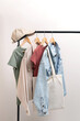 Basic women`s clothes and eco bag on white background. Woman collection of clothes on a rack. Spring and summer fashion trending concept. Railing with stylish female clothes