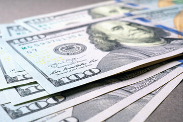 Wall Mural - american paper money. several one hundred dollar notes lie on a gray textured surface. focus on the 